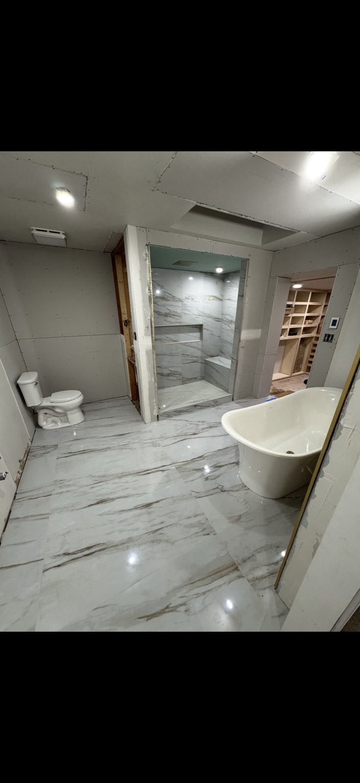 Luxury master bathroom full view with marble tile floors, freestanding soaking tub by 5 Star Pros DMV