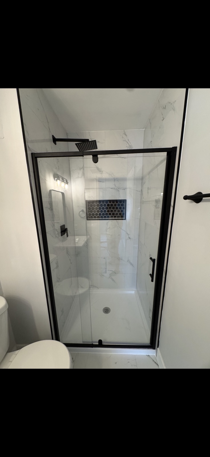 Glass walk-in shower with marble tile, hexagon mosaic niche and rain head by 5 Star Pros DMV